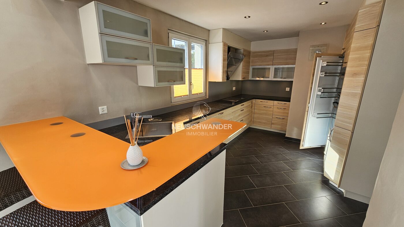 Cuisine avec un bar ouverte sur le séjour / salle à manger