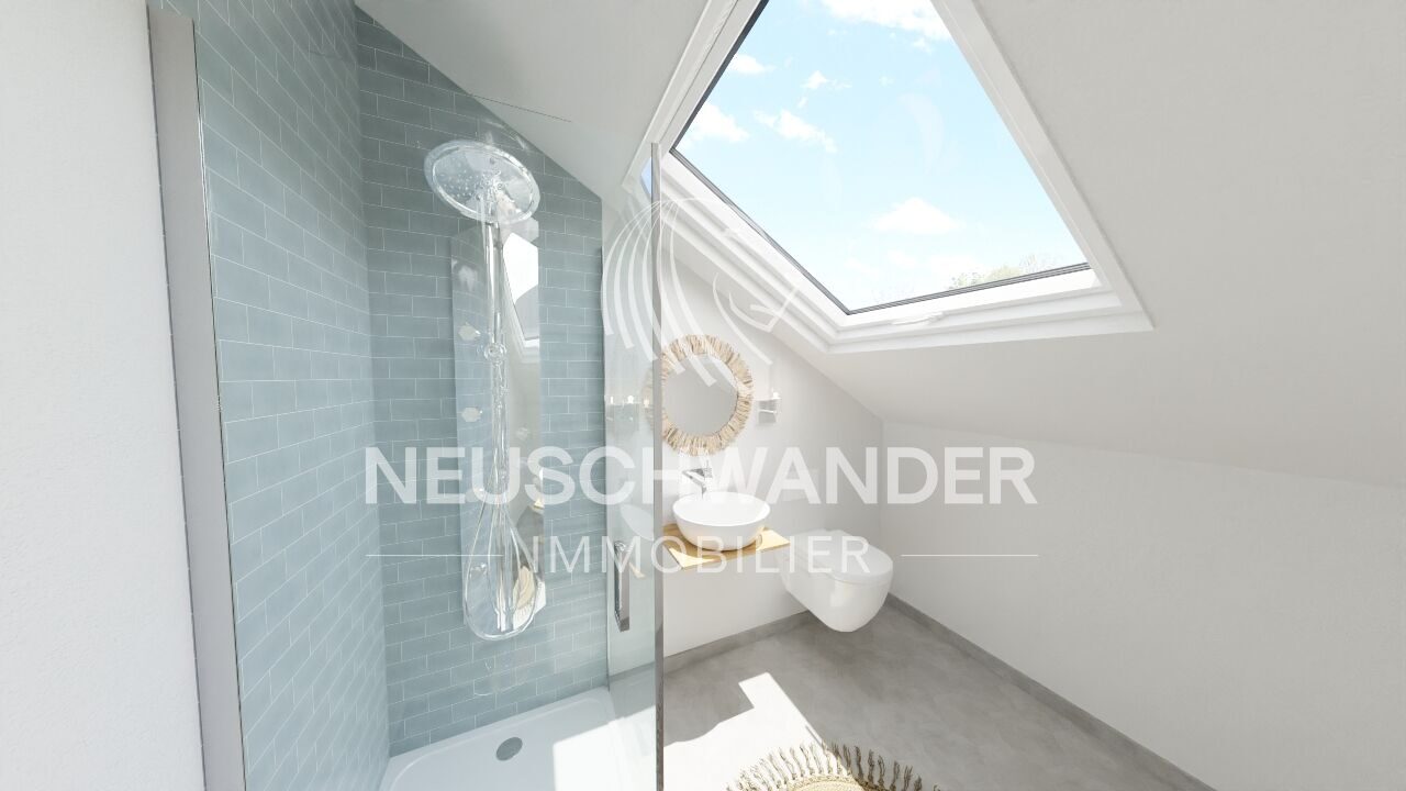 une petite salle de bains avec une lucarne, des toilettes blanches et une douche aux murs bleus