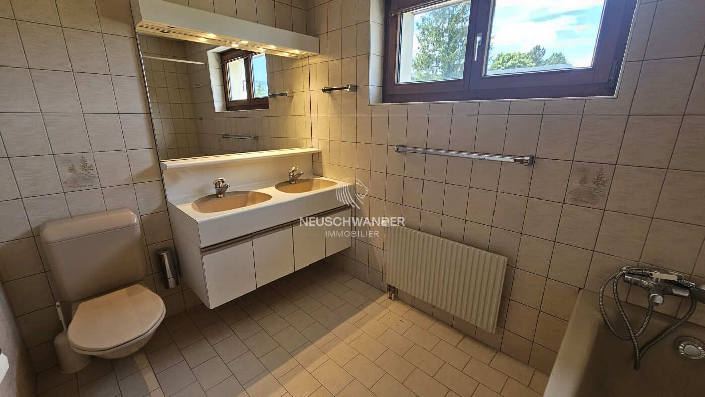 Salle de bains entièrement équipée avec fenêtre et double-vasque