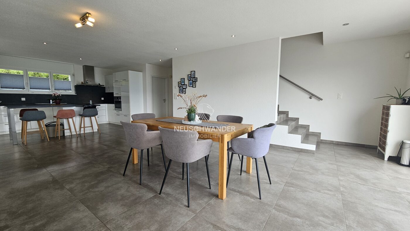 Salle à manger ouverte sur la cuisine et accès à l'étage